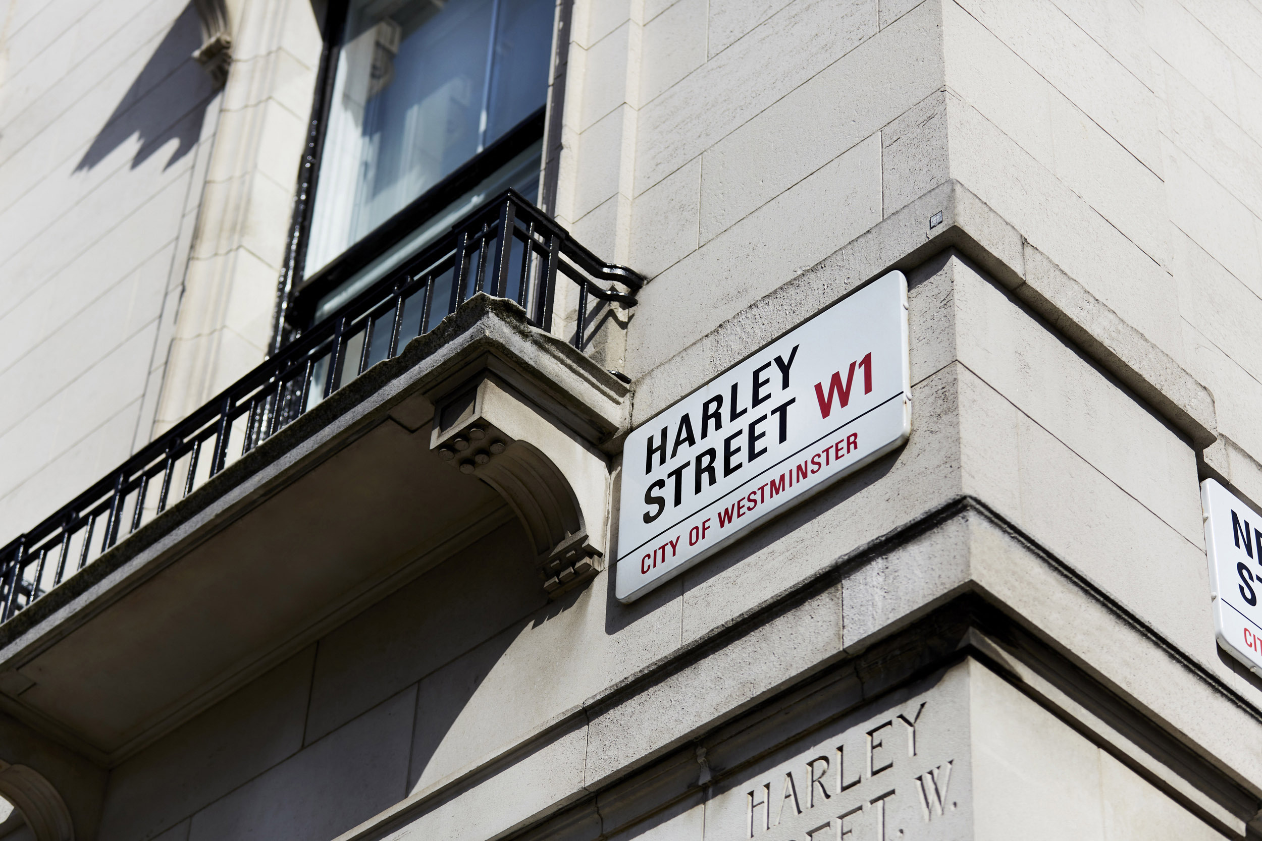 Harley Street W1 sign mounted on a corner of a historic London building in the City of Westminster, renowned for its private medical and psychology clinics.